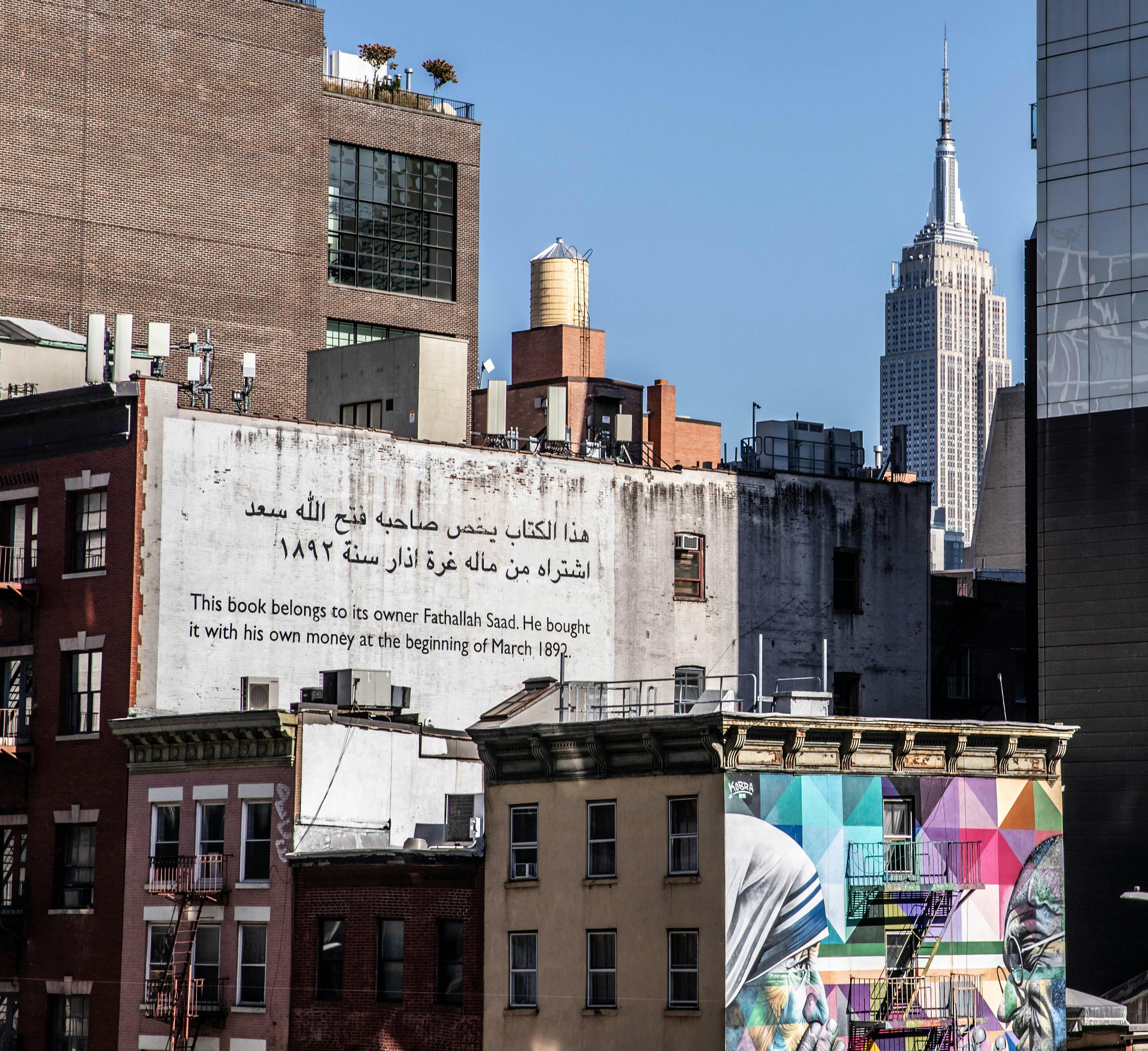 Colorful street art against the iconic New York City skyline featuring the Empire State Building.