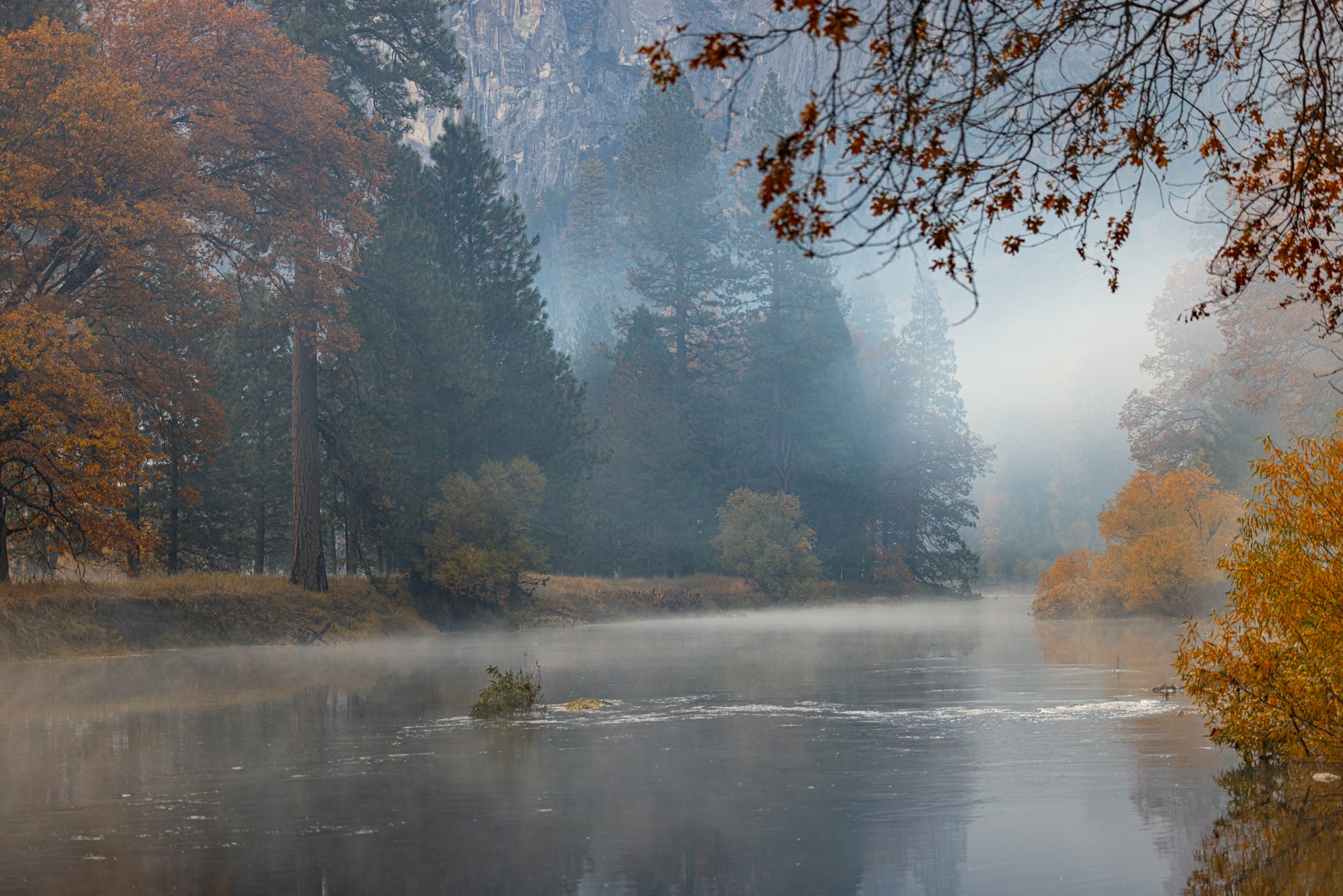 Serene misty lake at dawn with calm still waters reflecting the peaceful surroundings