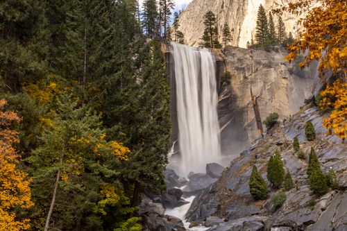 Free Majestic Vernal Fall cascades amid vibrant autumn foliage in Yosemite. Stock Photo