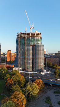 Aerial view of a modern high-rise under construction in Leeds city center during autumn, with clear skies.