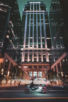 Dramatic night view of downtown Charlotte, NC, with illuminated skyscrapers and blurred motion of light traffic.