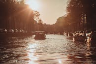 在充满活力的日落时分，乘船宁静地游览阿姆斯特丹的标志性运河，尽显这座城市的风采