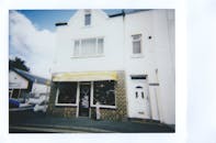 一家古色古香的商店，其经典外观在瞬间被电影风格捕捉，透出怀旧之情