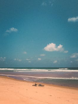 Peaceful beach view featuring a lone bicycle on the sand at Barra do Cunhaú, Brazil.