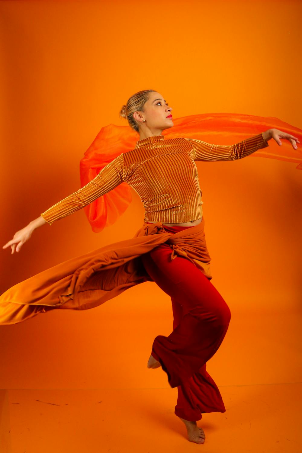 Dynamic Dance Pose in Vibrant Orange Studio Setting · Free Stock Photo