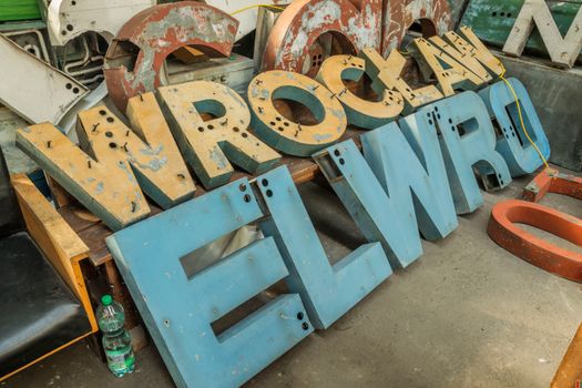 Collection of worn vintage neon letters at an industrial workshop in Wrocław, Poland.