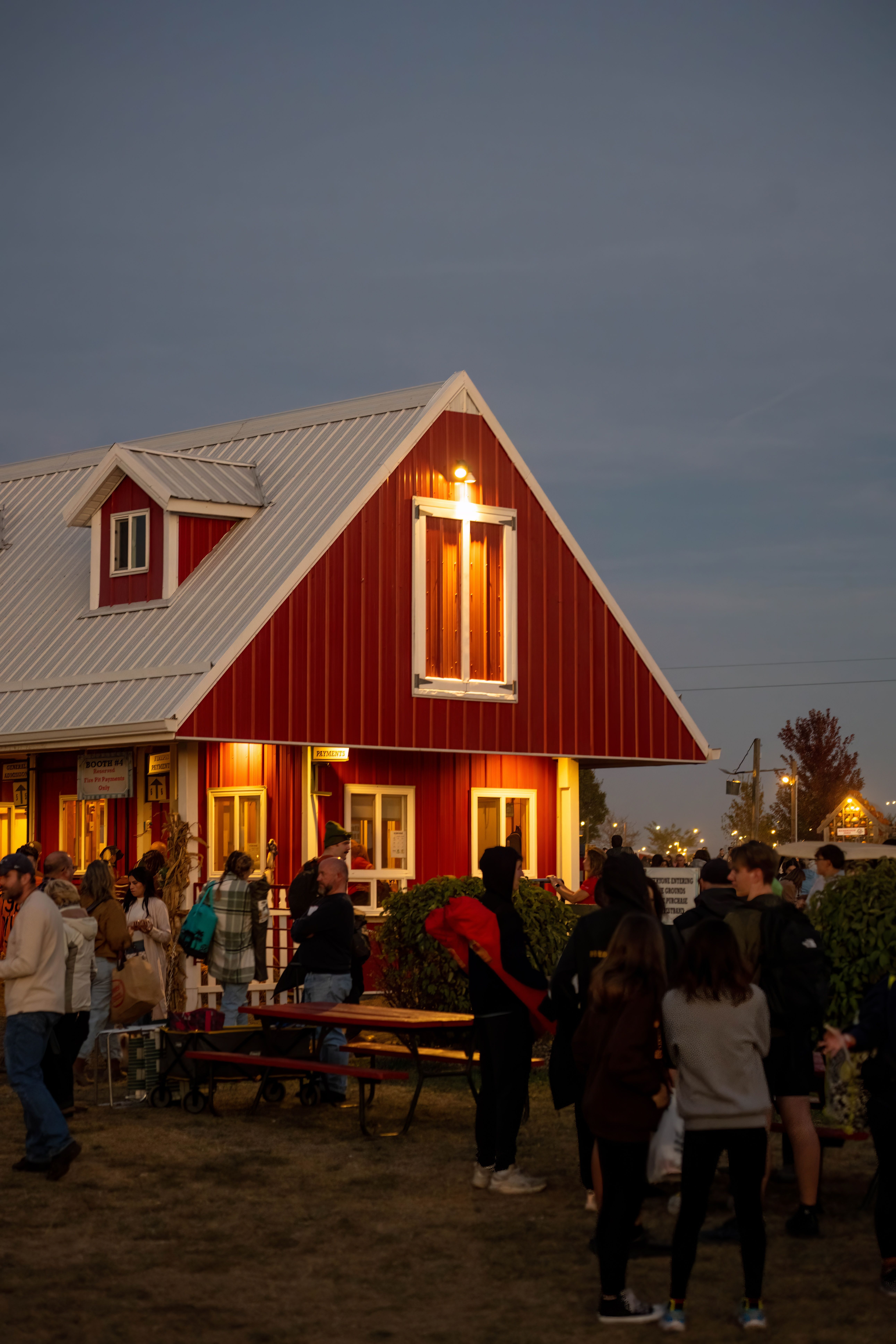 Lively evening gathering outside red barn in Illinois - historic barns