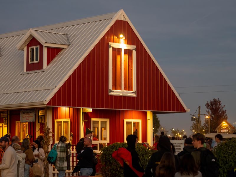 Lively evening gathering outside red barn in Illinois - historic barns