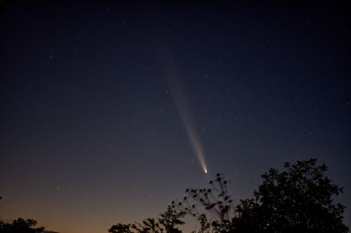 Free A stunning comet with a long tail streaks across the night sky in Chișinău, Moldova. Stock Photo