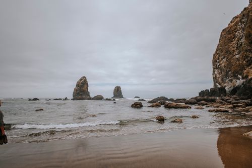 Free Peaceful beach scene with iconic sea stacks and cloudy sky. Stock Photo