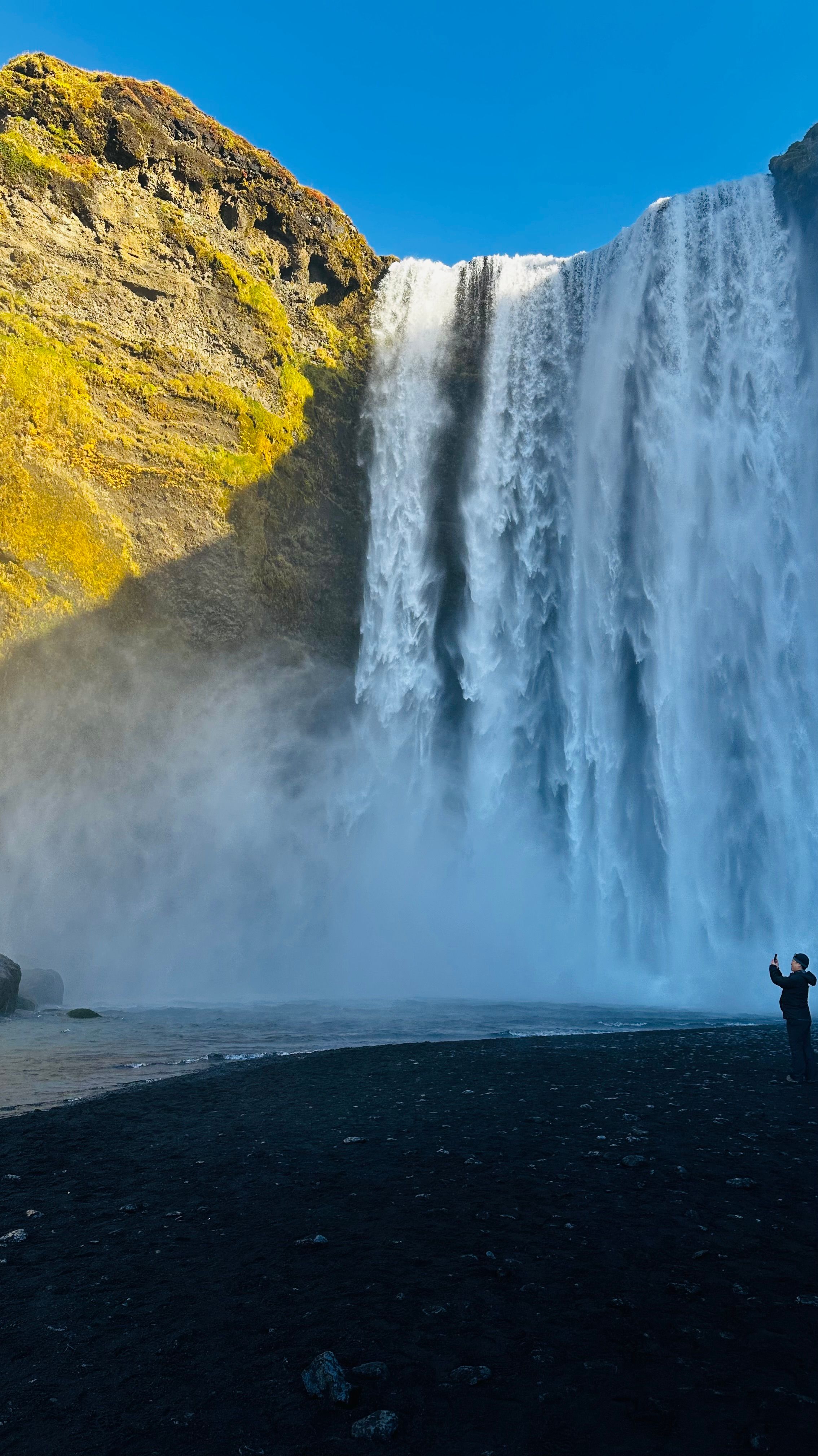 Skogafoss waterfall in southern Iceland with green moss-covered cliffs