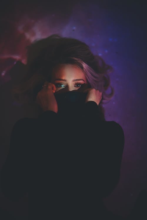 Free Woman Covering Her Mouth Inside Dark Room Stock Photo
