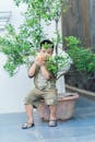 Child Playing with Water Gun Amongst Plants