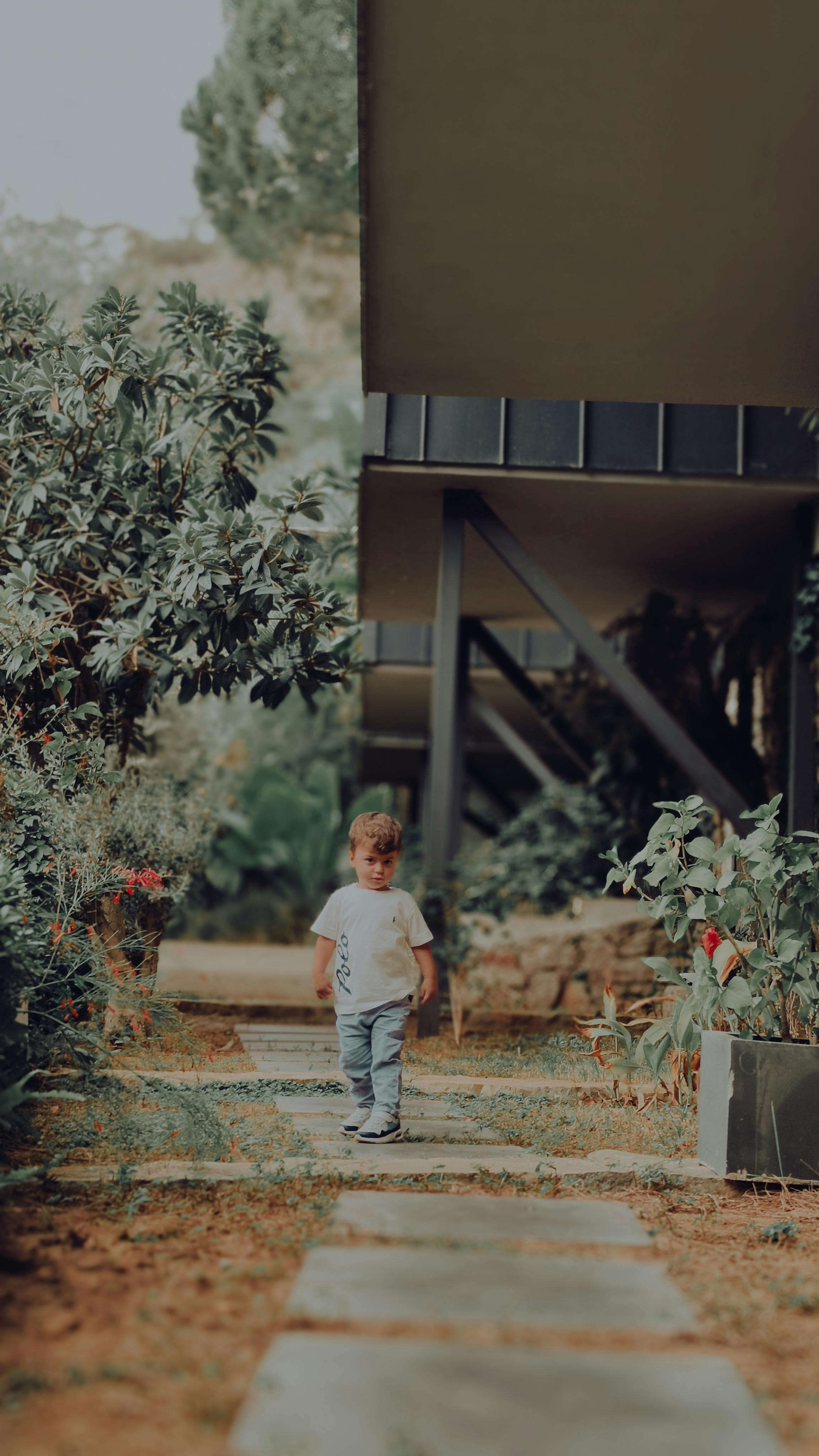 Child Walking Along Garden Pathway Outdoors · Free Stock Photo