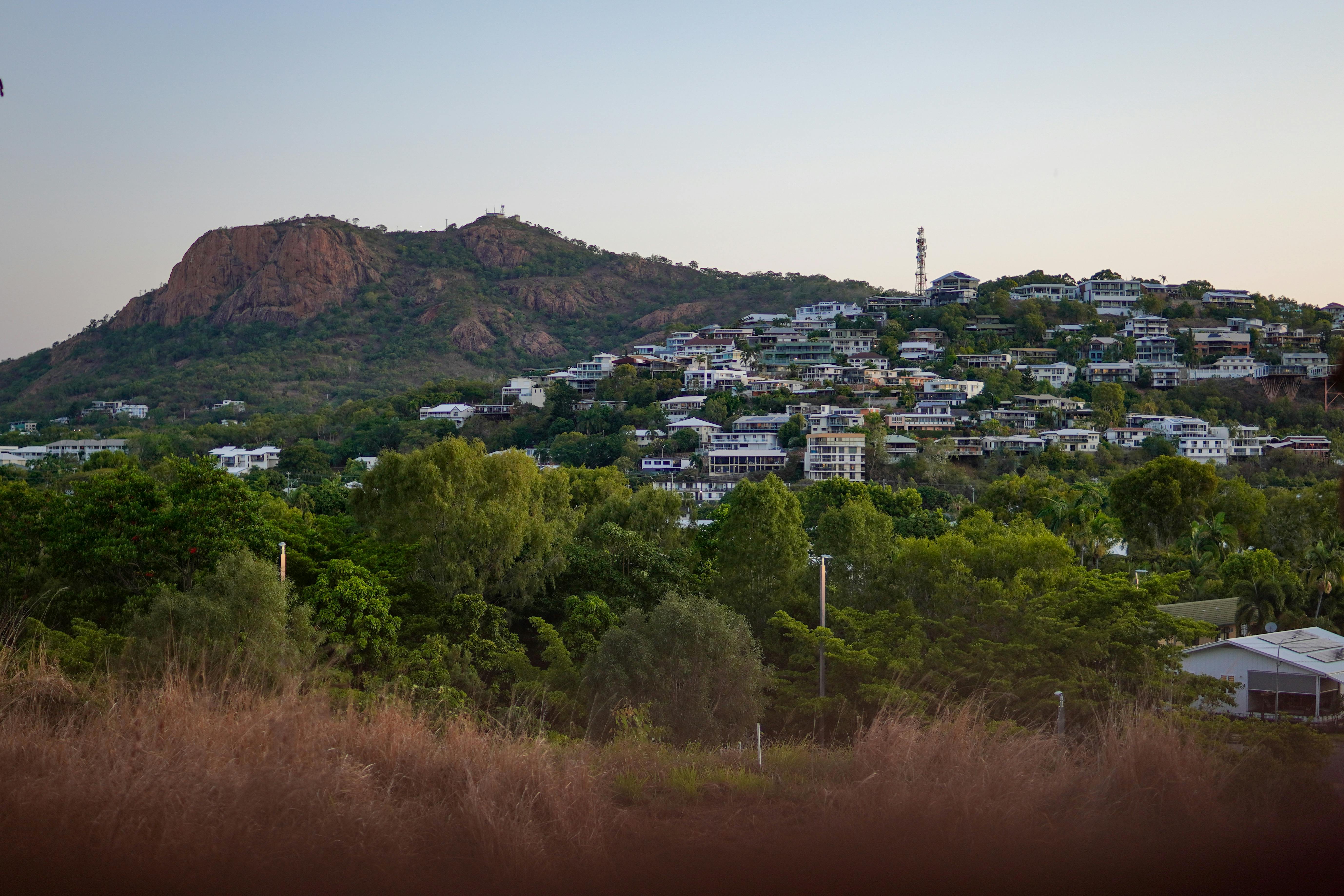 Beautiful view of Castle Hill in Townsville, Australia, surrounded by lush greenery at dusk.