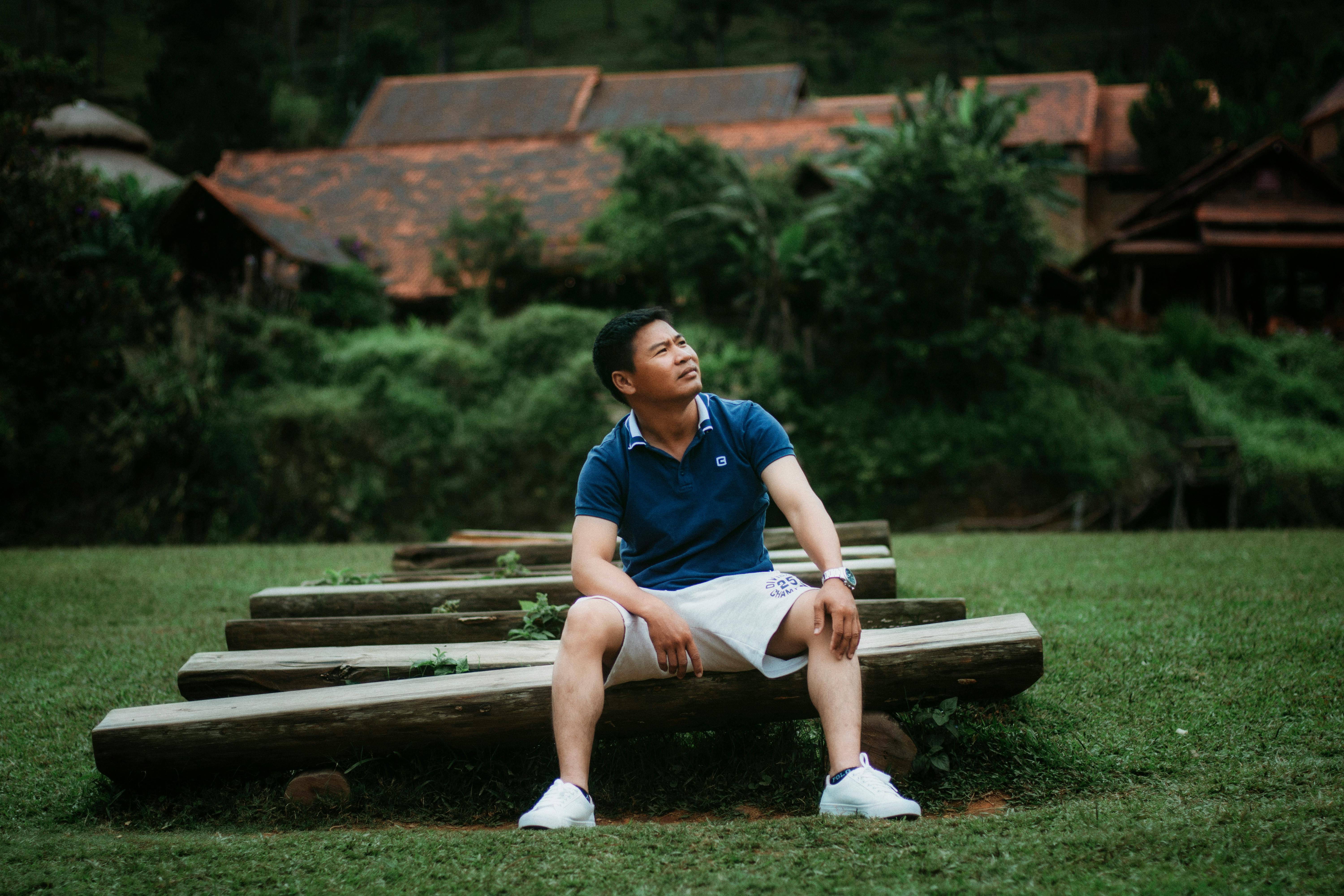 一名男子穿着休闲装，坐在户外，享受着森林的宁静背景