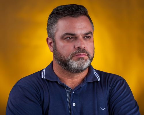 Free A mature man with a beard looks thoughtfully, set against a striking yellow background. Stock Photo
