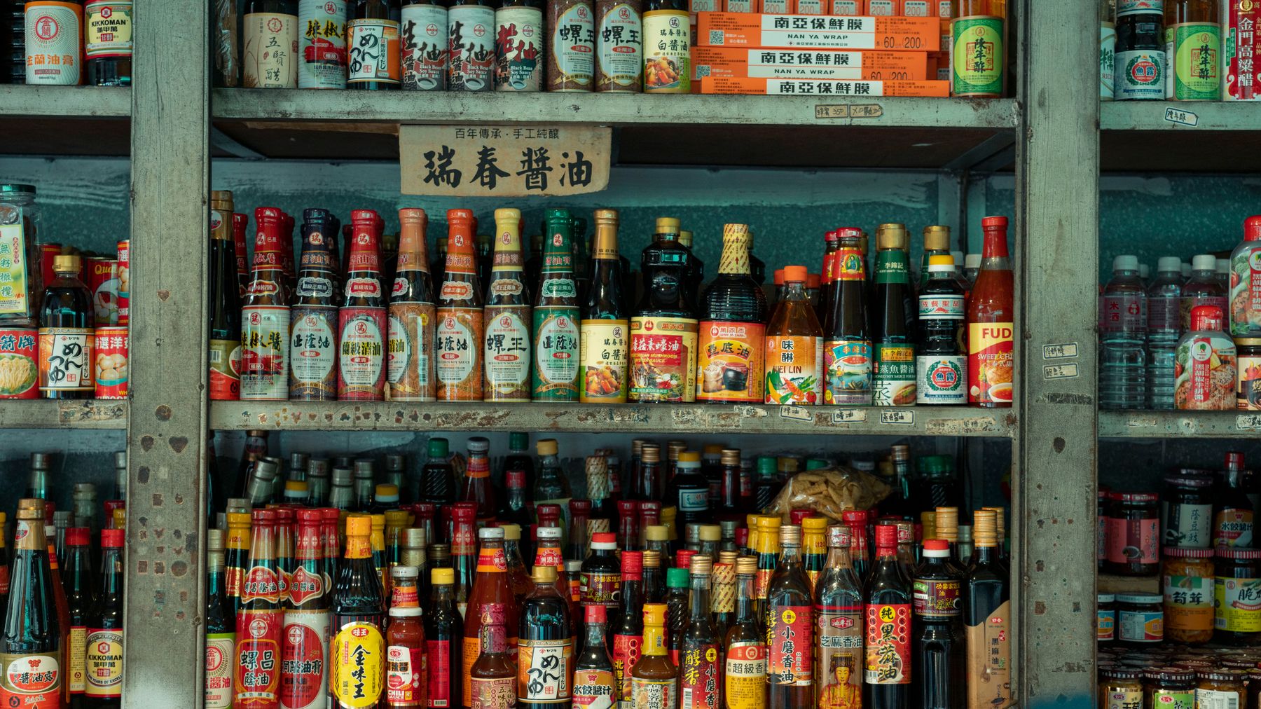 Exhibición colorida de salsas y condimentos asiáticos en los estantes de un mercado en Nueva Taipéi, Taiwán.