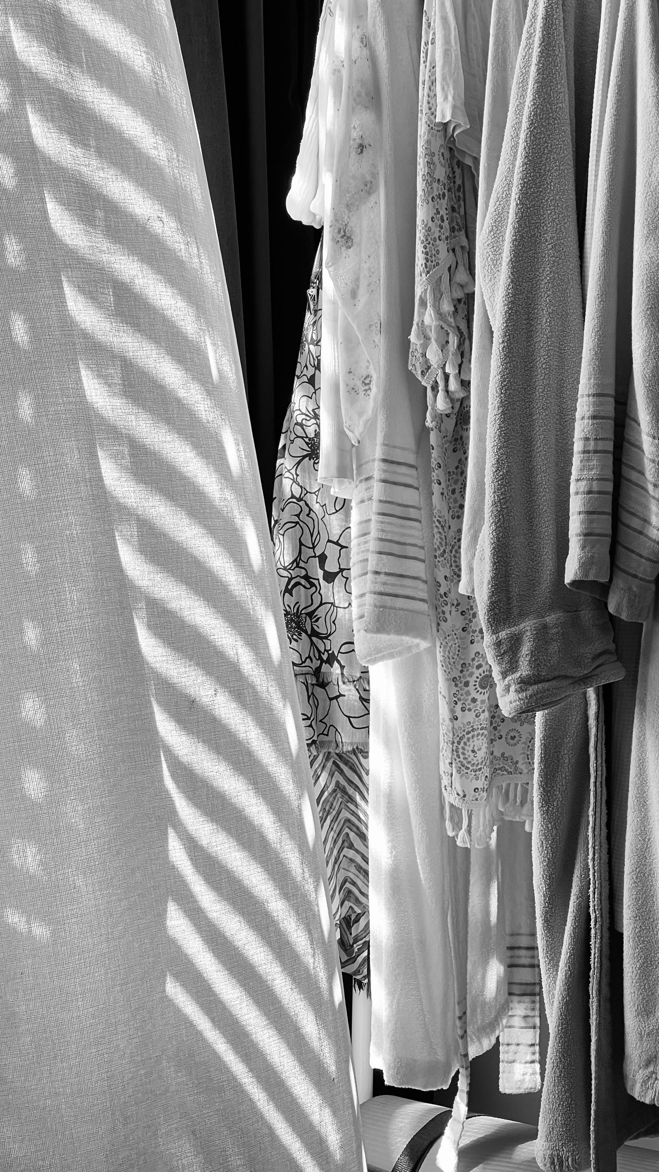 Monochrome image showcasing patterned shadows on white and textured fabrics.