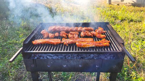 Free Outdoor Barbecue Grill with Smoked Meat and Ribs Cooking on Charcoal Stock Photo