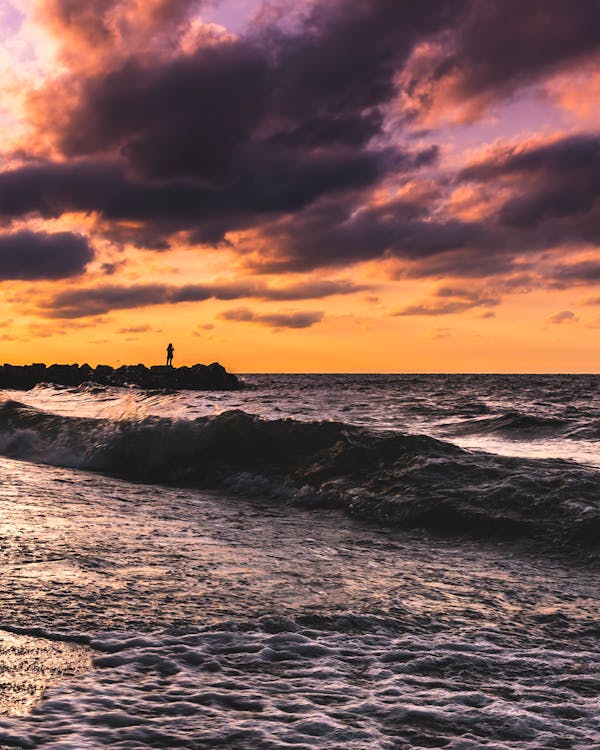 Photo of Person Standing on Seashore