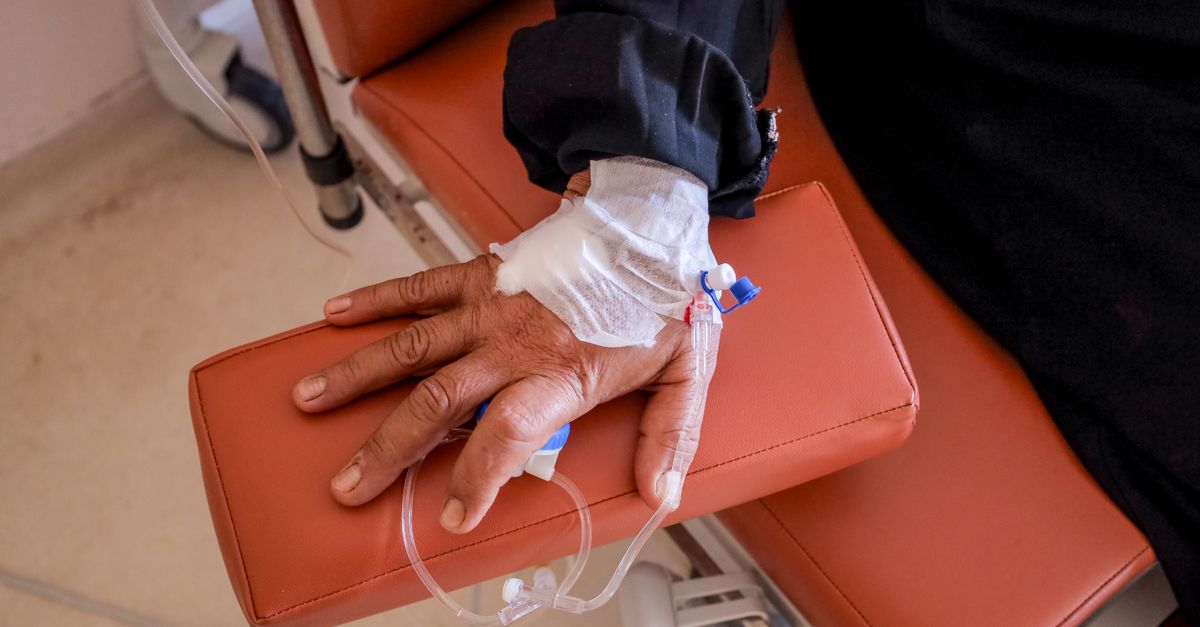 Close-up of a patient's hand receiving chemotherapy treatment in a medical facility.