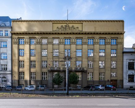 Symmetrical view of a historic building in Łódź, Poland, with a visible moon.