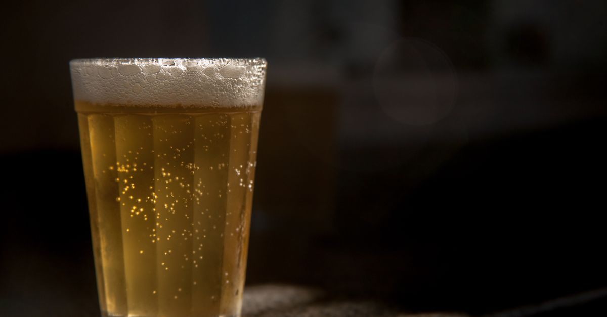 Um copo espumoso de lager capturado em iluminação quente, evocando relaxamento e prazer.