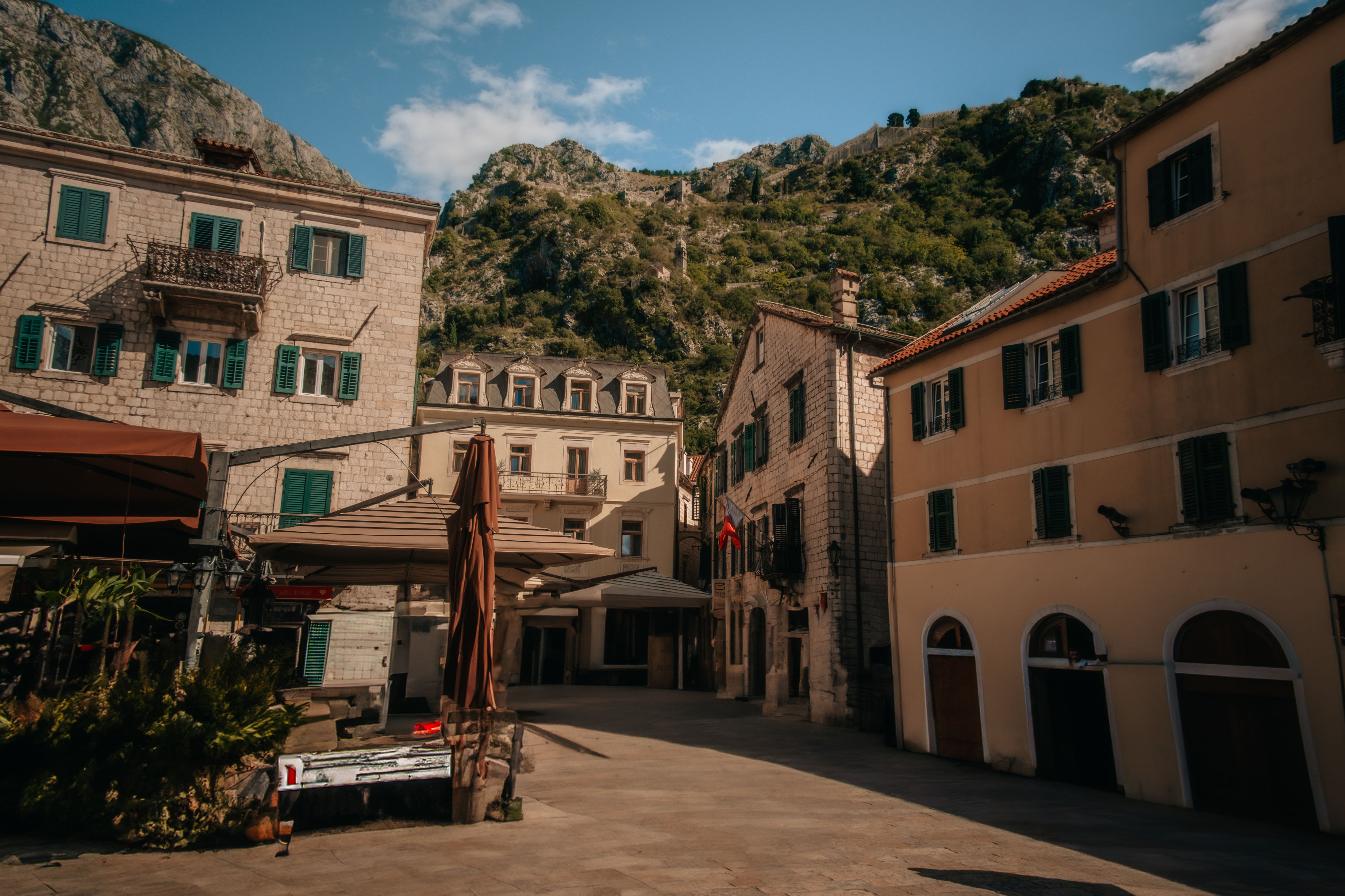 Kotor, Montenegro: um dos cenários mais deslumbrantes dos Bálcãs para quem escolhe trabalhar no exterior Vista aérea de Kotor Montenegro com a baía e as montanhas ao fundo em dia ensolarado