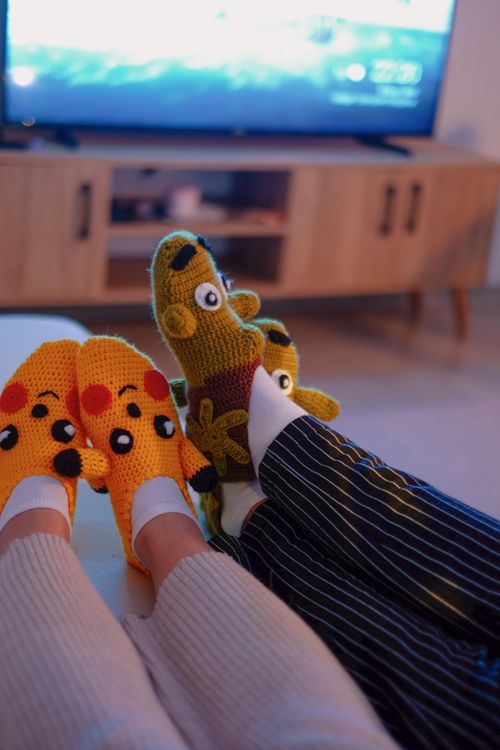 Free Relaxing indoors with cozy crochet animal slippers, perfect for a comfortable night in. Stock Photo
