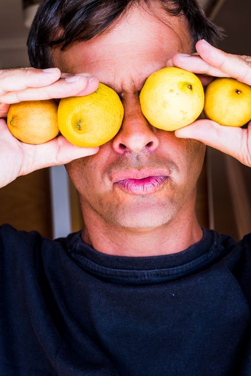 Free Man holding lemons over his eyes for a playful, humorous portrait. Stock Photo