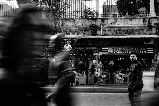 Dynamic black and white photo capturing busy street life in Istanbul with motion blur.