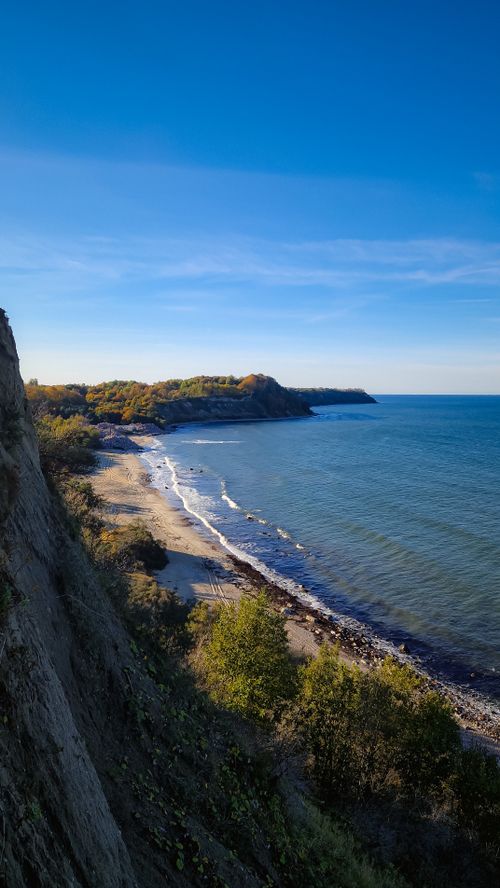 Free Idyllic coastal landscape with cliffs, beach, and clear blue sea under a sunny sky. Stock Photo