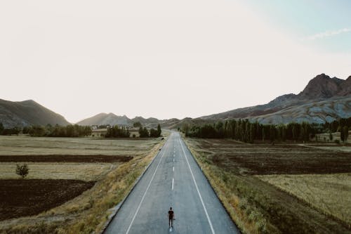 A Person Standing Alone on Country Road