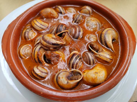 A delicious bowl of Spanish caracoles in rich sauce, showcasing traditional Spanish cuisine.