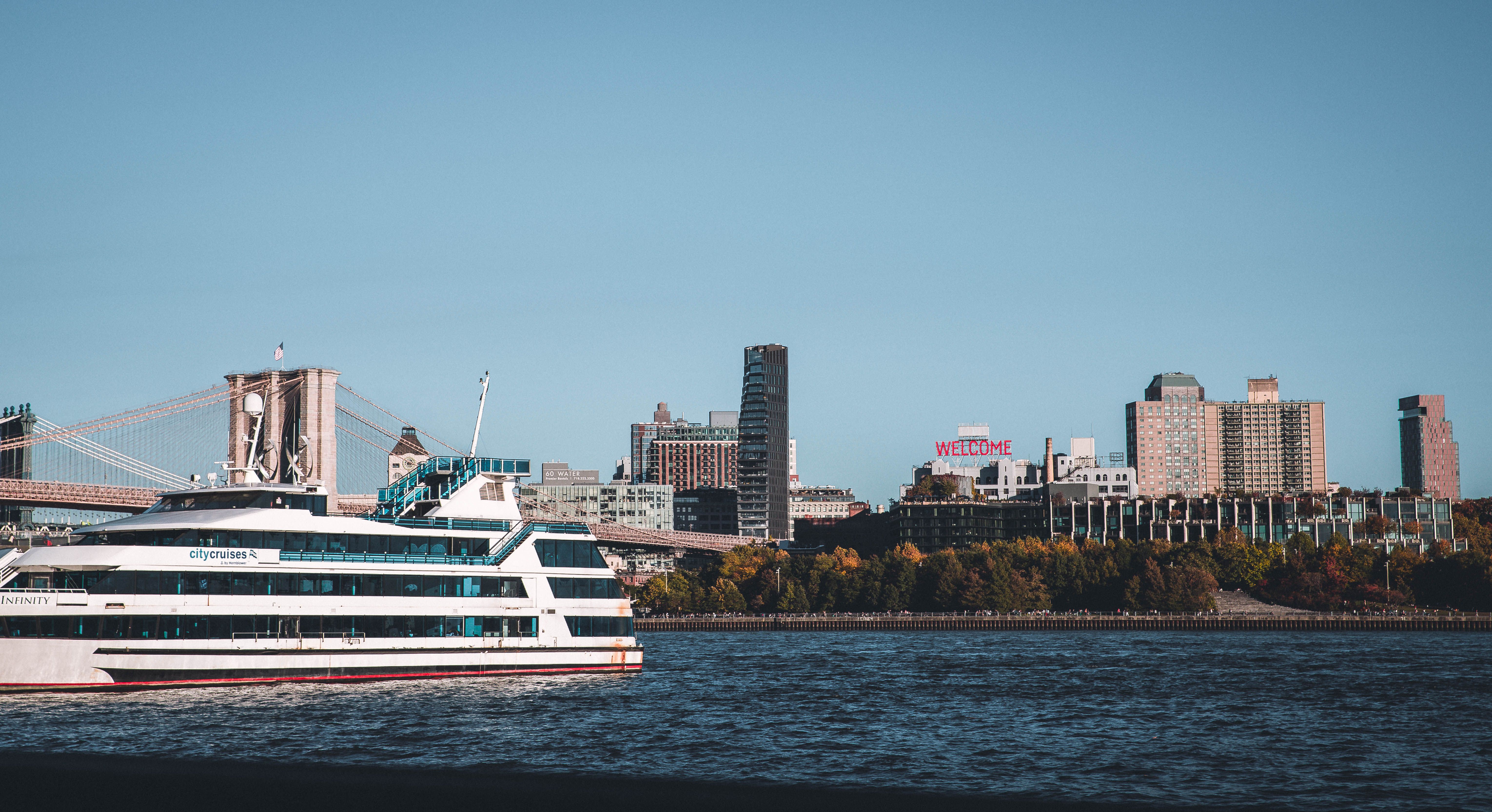 Stunning New York Harbor Brunch Cruise Review: A Luxury Weekend Experience on the Water Review 2026 - A cruise ship sails on the East River with the New York City skyline, including the Brooklyn Bridge, in view.