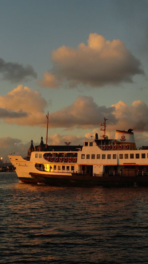 Free A serene passenger ferry sails during a vibrant sunset over calm waters. Stock Photo
