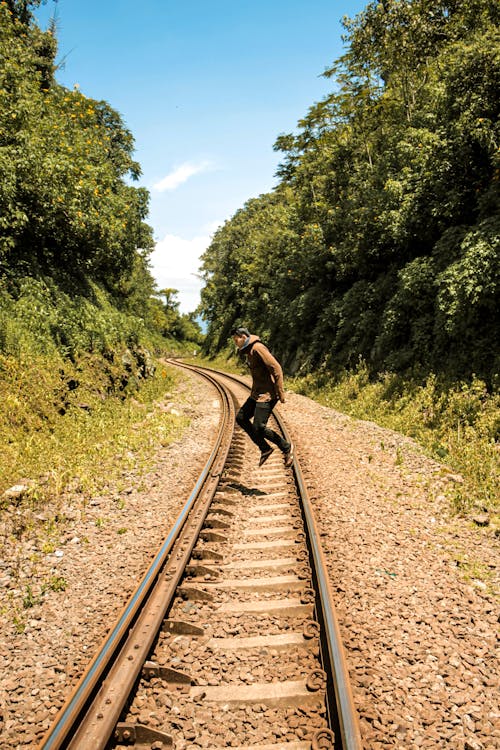 Фотография человека, прыгающего на железнодорожном пути