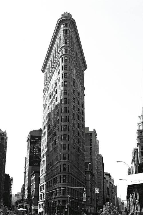 Free Iconic Flatiron Building in NYC showcasing classic architecture against the urban skyline. Stock Photo