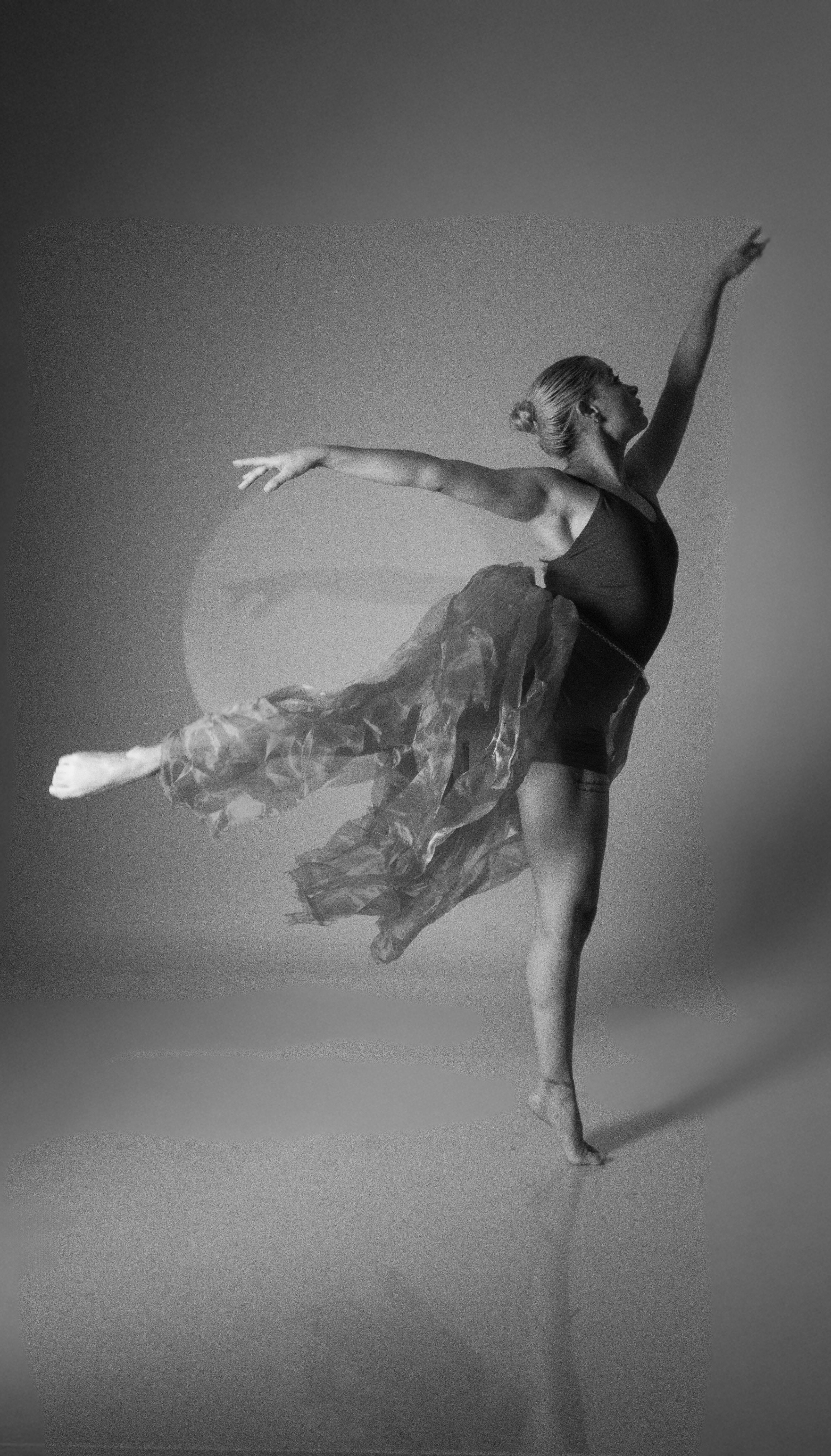 Graceful ballerina captured in motion under spotlight, showcasing dance elegance.