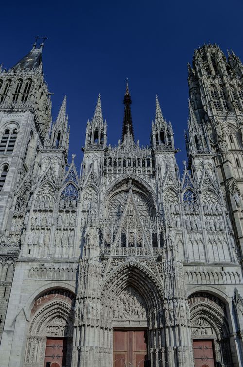 Free Majestic Gothic facade of Rouen Cathedral in Normandie against a clear blue sky. Stock Photo