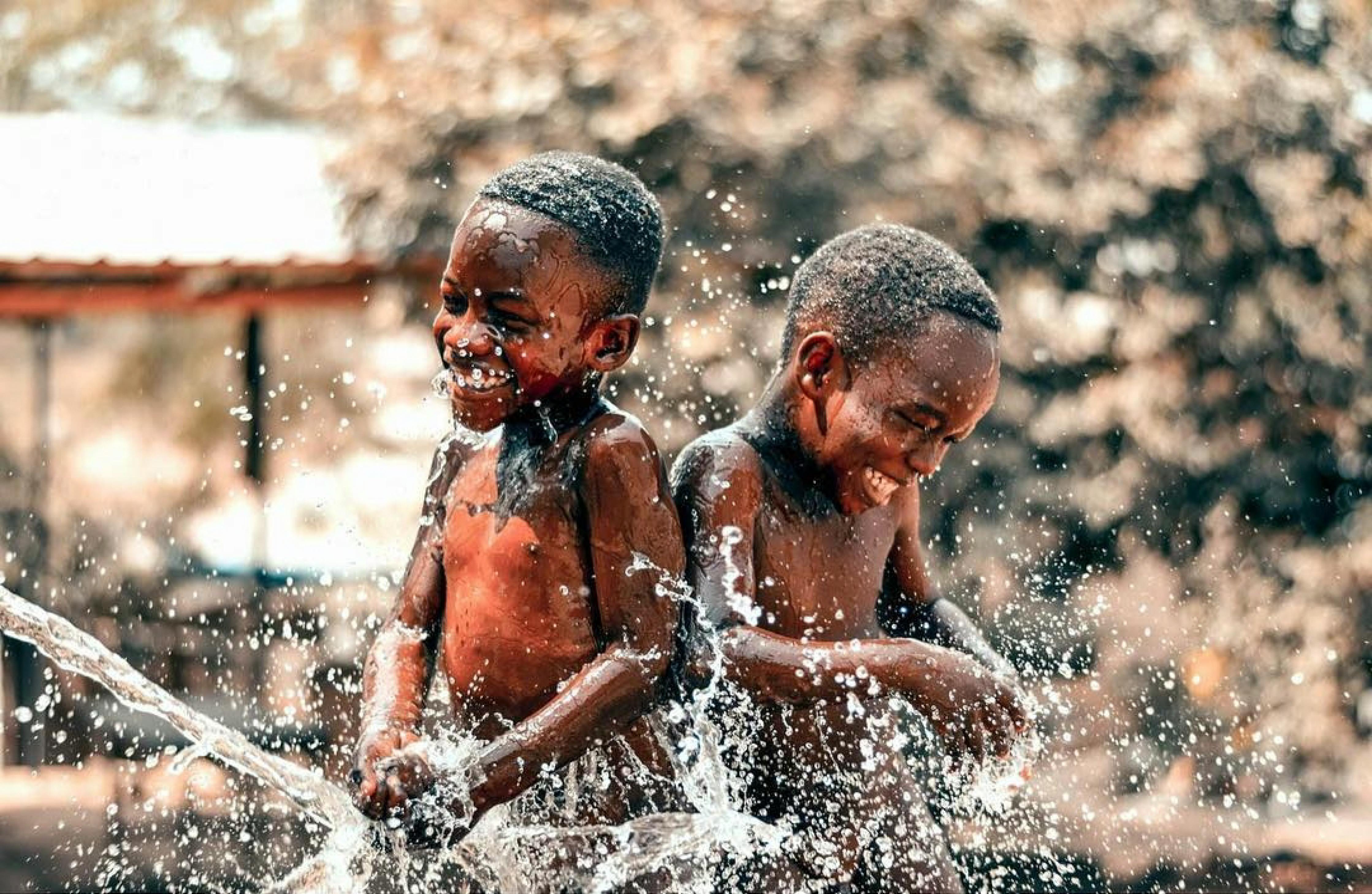 two boys taking bath outside