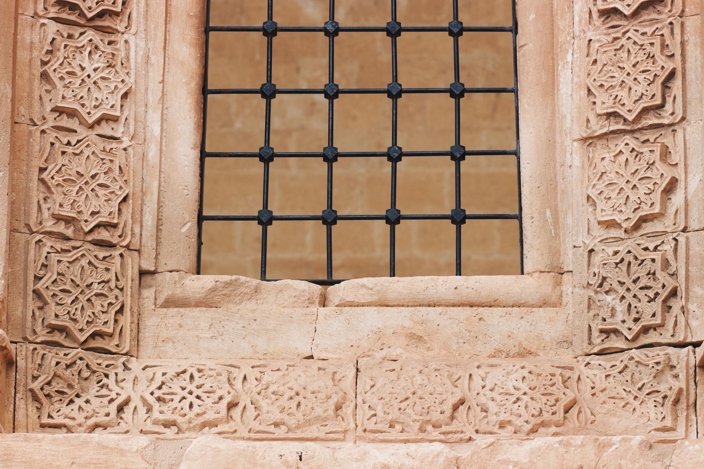 Ornate Stone Carved Window with Iron Grate Design · Free Stock Photo