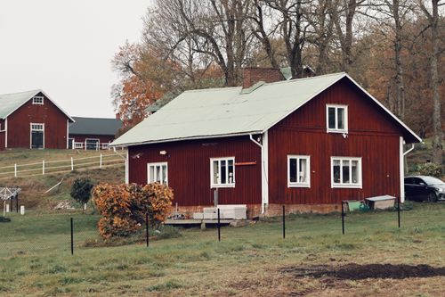Free A charming red wooden house in the Swedish countryside during fall. Stock Photo
