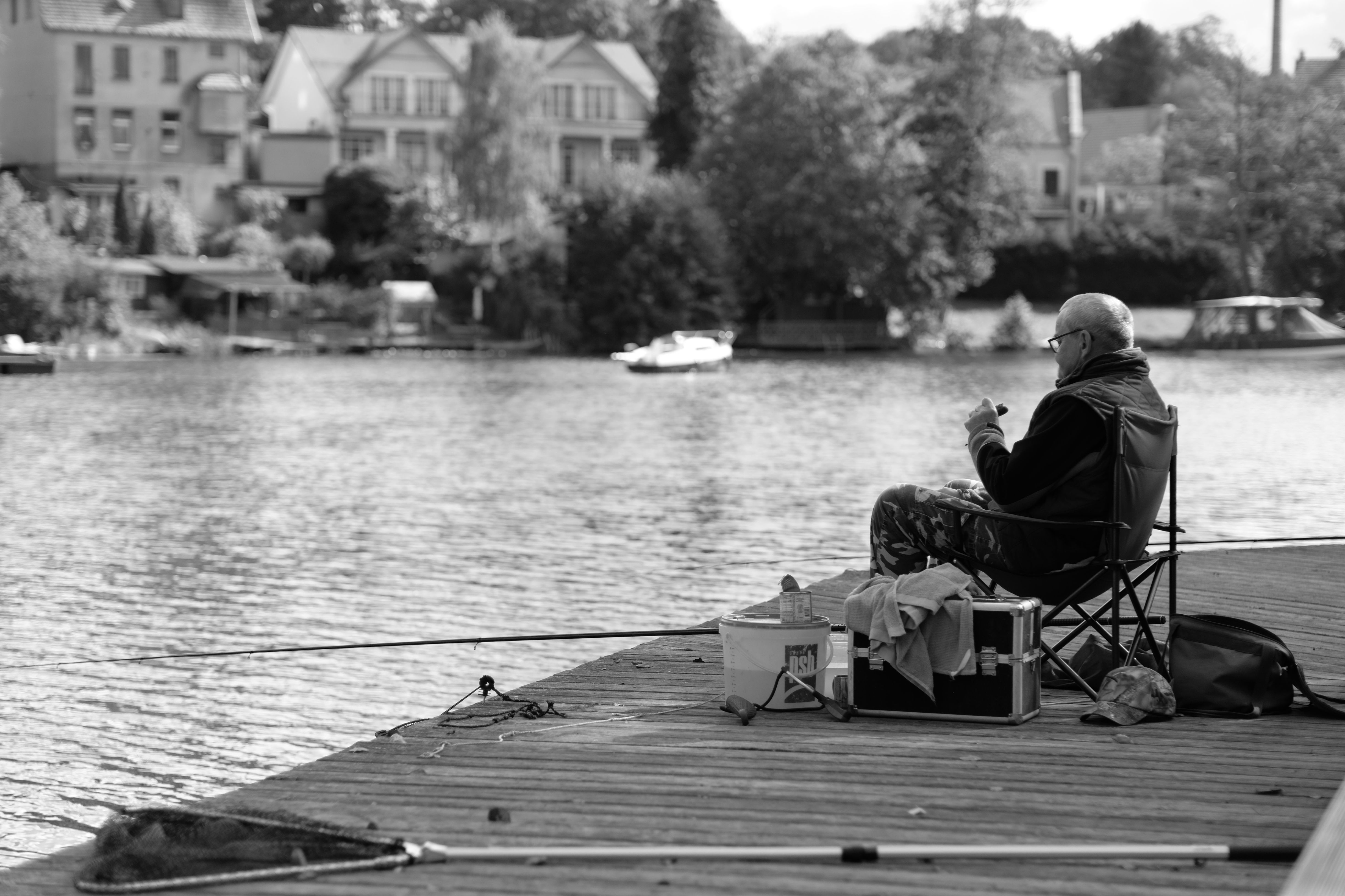 Man Fishing on Tranquil Lake Pier · Free Stock Photo