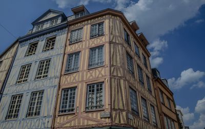 Bâtiment traditionnel à colombages vibrant sous un ciel dégagé à Rouen, Normandie.