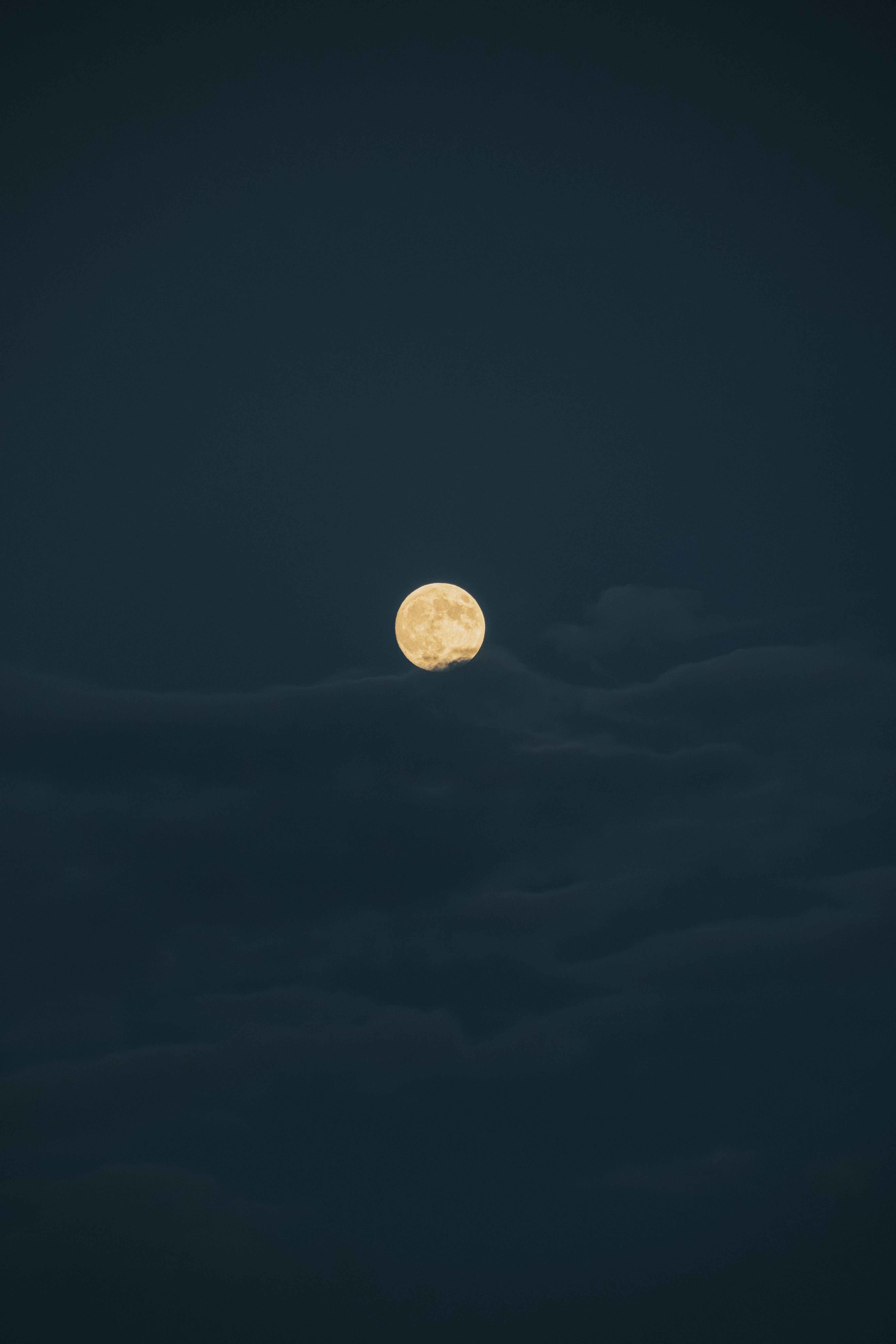 A mystical full moon shining brightly amidst a cloudy night sky in Istanbul.