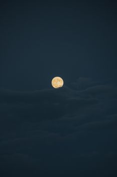 A mystical full moon shining brightly amidst a cloudy night sky in Istanbul.