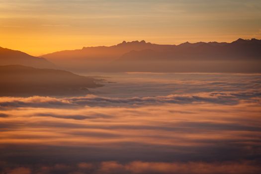 Stunning sunset view of mountains and clouds creating a serene landscape.