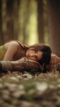 A woman rests on a log in a serene woodland, evoking a dreamy mood.